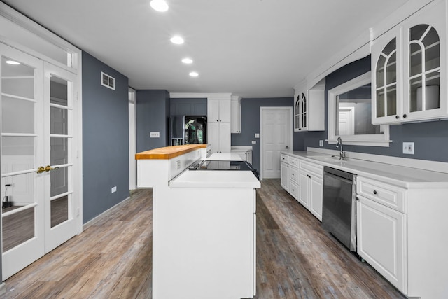 kitchen featuring dishwasher, butcher block countertops, an island with sink, and dark hardwood / wood-style floors