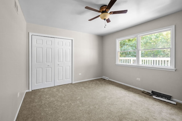 unfurnished bedroom featuring ceiling fan, carpet flooring, and a closet