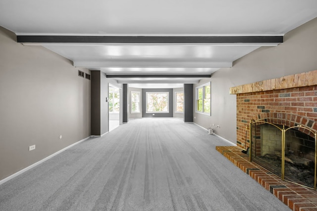 unfurnished living room with beam ceiling, dark colored carpet, and a fireplace