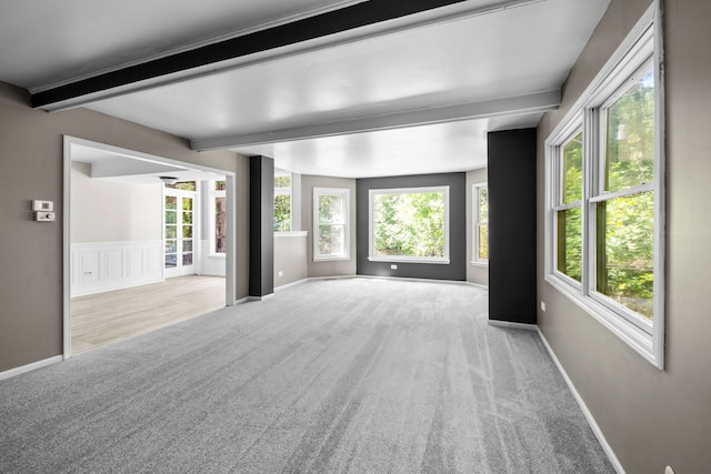 interior space featuring light colored carpet and beam ceiling