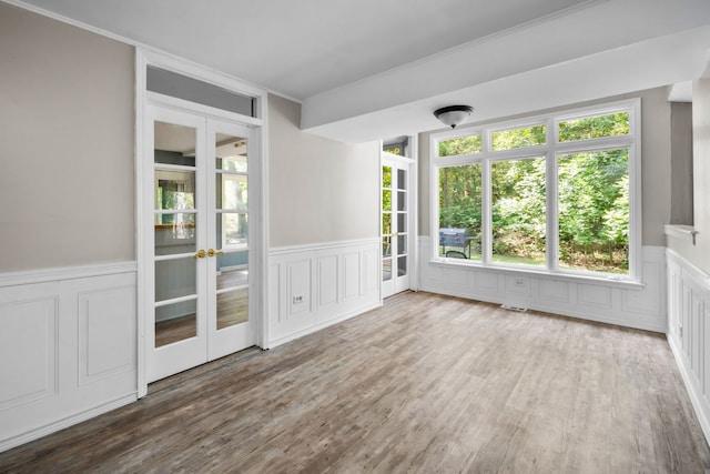 empty room with hardwood / wood-style floors and crown molding