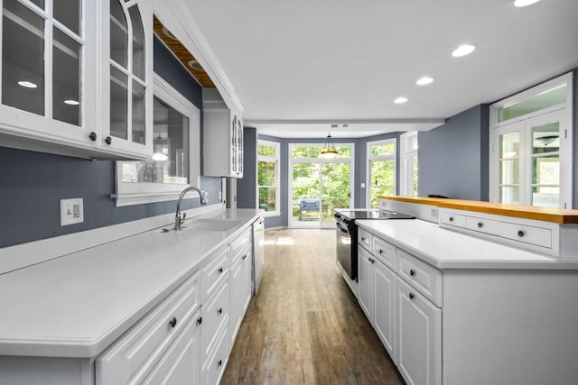 kitchen featuring white cabinetry, sink, dark hardwood / wood-style floors, stainless steel electric stove, and a kitchen island