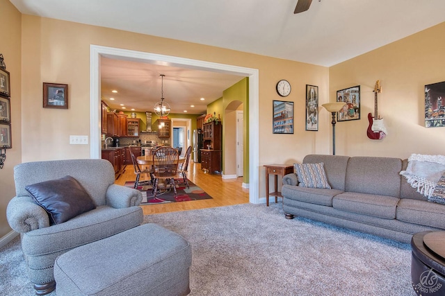 living room with light carpet, ceiling fan, and sink