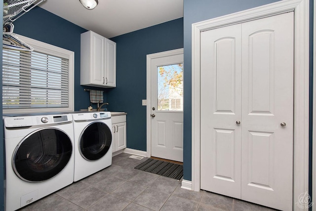 laundry area with washing machine and dryer, sink, light tile patterned floors, and cabinets