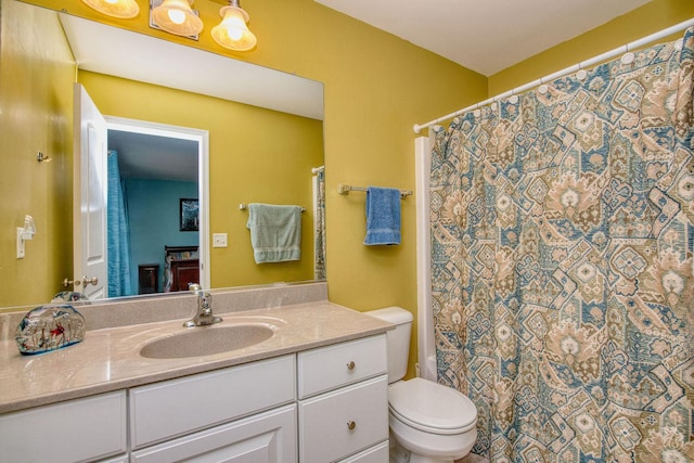 bathroom with curtained shower, vanity, and toilet