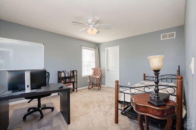 carpeted office space featuring ceiling fan