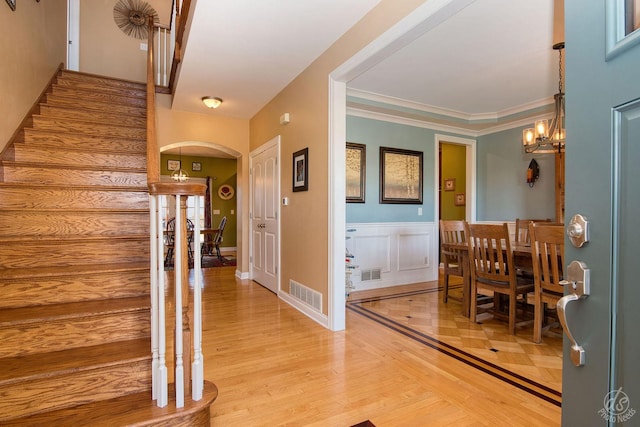 foyer entrance featuring wood-type flooring and an inviting chandelier