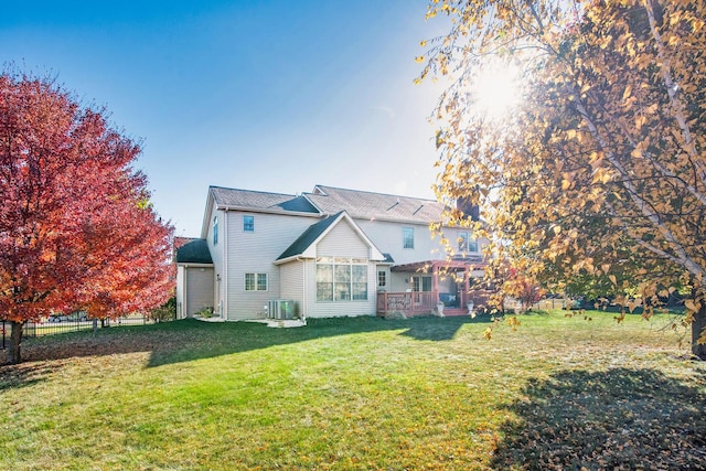 back of house featuring a yard, central AC unit, and a wooden deck