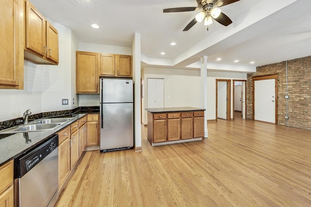 kitchen with stainless steel appliances, sink, ceiling fan, light hardwood / wood-style flooring, and brick wall