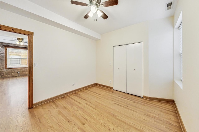 unfurnished bedroom featuring a closet, light hardwood / wood-style floors, and ceiling fan