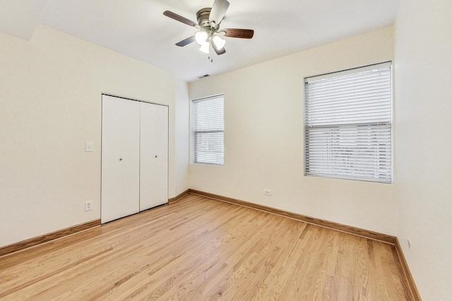 unfurnished bedroom with ceiling fan, a closet, and light wood-type flooring