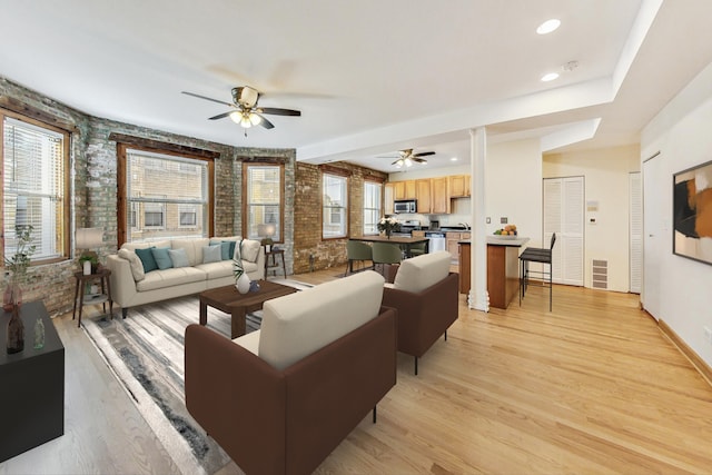 living room featuring ceiling fan and light hardwood / wood-style flooring