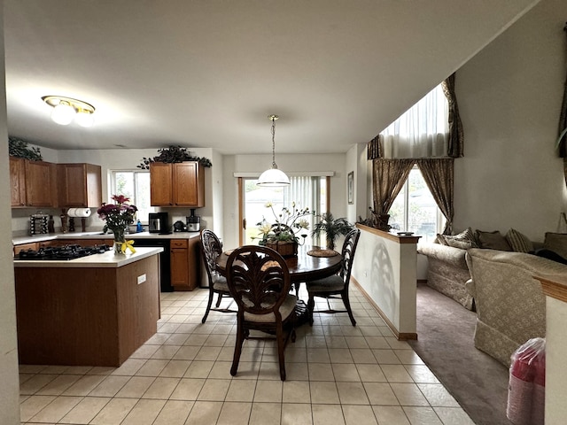 kitchen with hanging light fixtures, light tile patterned floors, and black gas stovetop