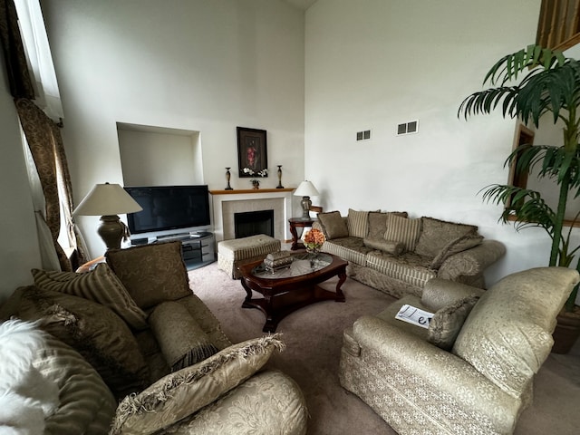 living room featuring a towering ceiling and carpet flooring