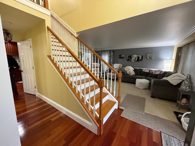 stairs featuring hardwood / wood-style floors and crown molding