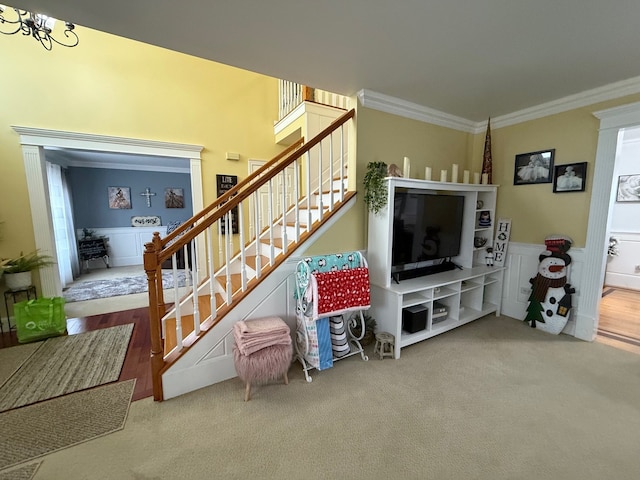 living room with crown molding, carpet floors, and a notable chandelier