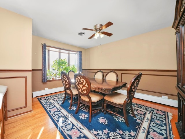 dining area with ceiling fan, baseboard heating, and light hardwood / wood-style floors