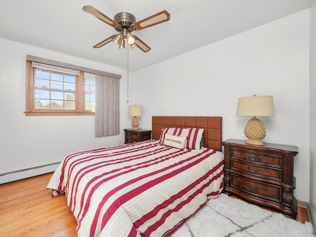 bedroom featuring baseboard heating, light wood-type flooring, and ceiling fan