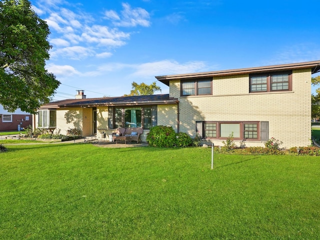 back of property featuring a patio area and a yard