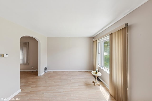 1242 E 98th St, Chicago, IL 60628 - empty room with light wood-type flooring, arched walkways, and baseboards