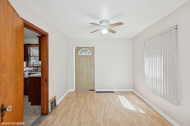 1242 E 98th St, Chicago, IL 60628 - foyer entrance featuring ceiling fan, light wood-style floors, and baseboards