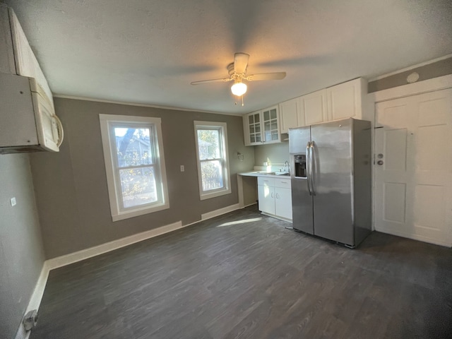 kitchen with white cabinets, dark hardwood / wood-style floors, stainless steel fridge, ceiling fan, and a textured ceiling