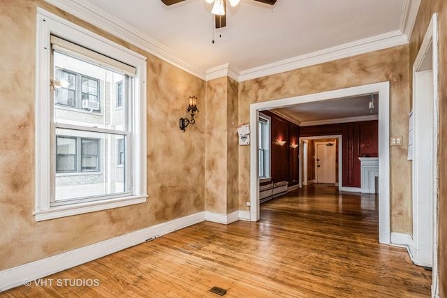 interior space featuring ceiling fan, hardwood / wood-style flooring, crown molding, and a baseboard heating unit