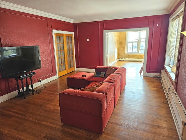 living room featuring ornamental molding, wood-type flooring, baseboard heating, and a healthy amount of sunlight