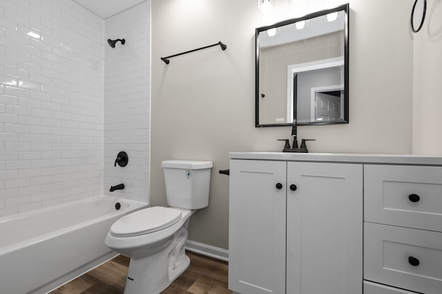 full bathroom with hardwood / wood-style flooring, vanity, toilet, and tiled shower / bath combo