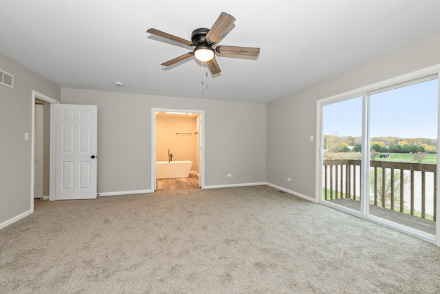 unfurnished bedroom featuring access to outside, light colored carpet, ceiling fan, and ensuite bathroom