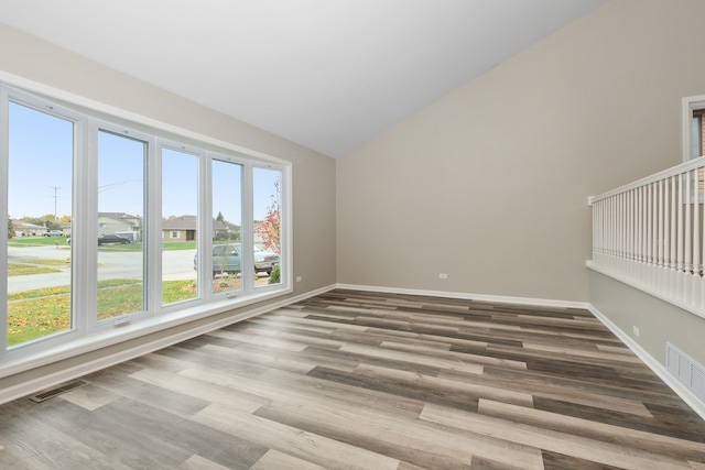 empty room featuring hardwood / wood-style flooring and lofted ceiling