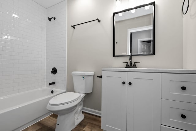 full bath featuring baseboards, toilet, wood finished floors, vanity, and  shower combination