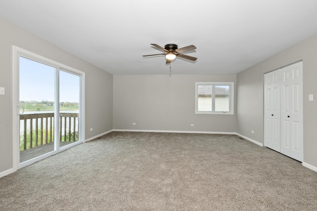 empty room with carpet flooring, baseboards, and ceiling fan