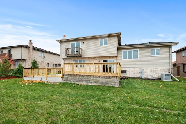 rear view of property with brick siding, central AC unit, a lawn, and a balcony