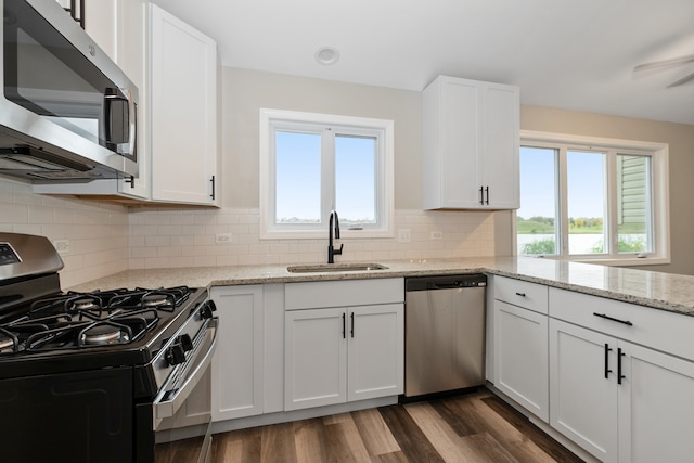 kitchen with white cabinetry, appliances with stainless steel finishes, decorative backsplash, sink, and dark wood-type flooring