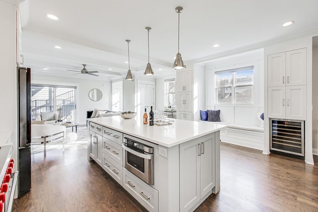 kitchen with white cabinetry, a center island, hanging light fixtures, and wine cooler