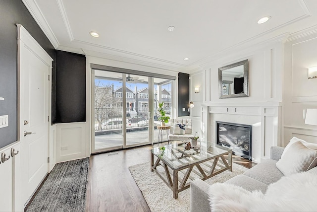 living room with hardwood / wood-style flooring and crown molding