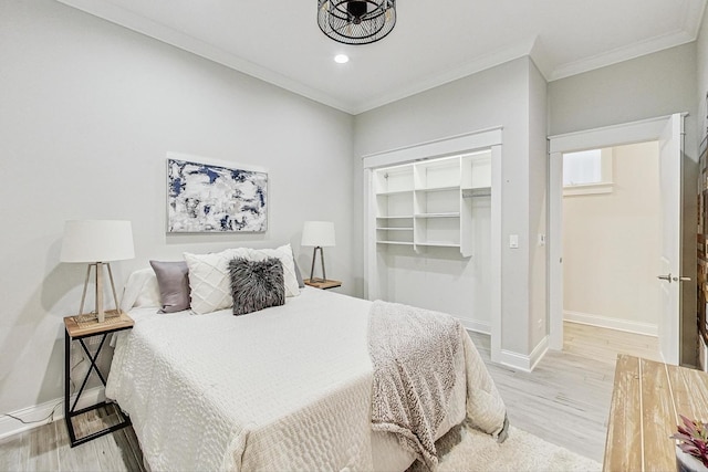 bedroom featuring crown molding, light hardwood / wood-style floors, and a closet