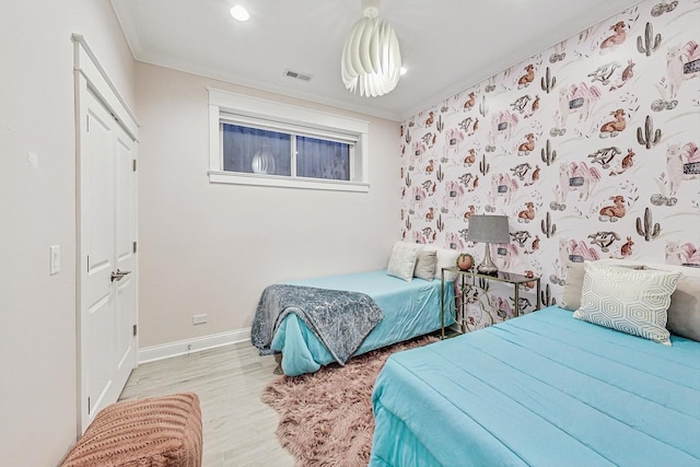 bedroom featuring ornamental molding and light wood-type flooring