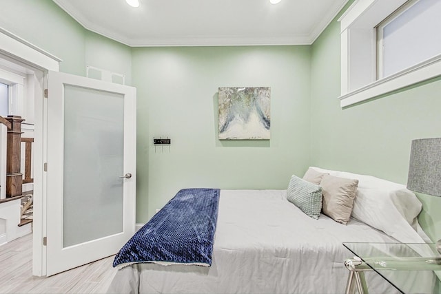 bedroom featuring ornamental molding and light hardwood / wood-style floors