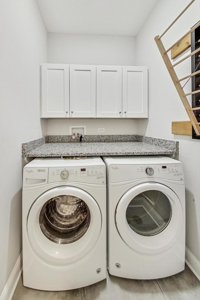 laundry area with independent washer and dryer and cabinets