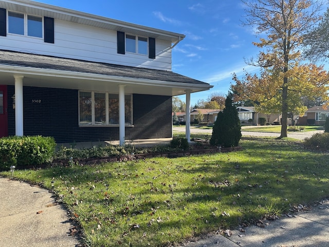 view of side of property with a porch and a yard