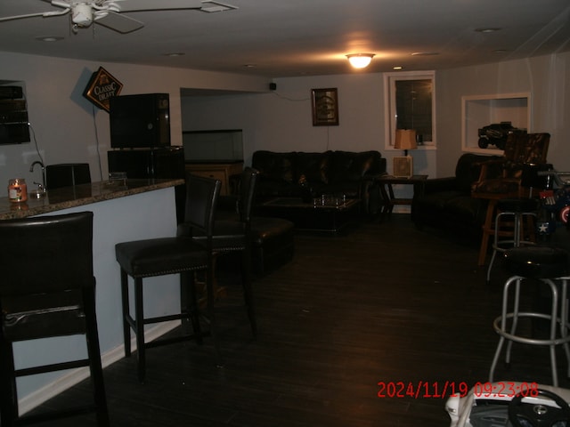 kitchen featuring dark hardwood / wood-style flooring, stone countertops, ceiling fan, and sink