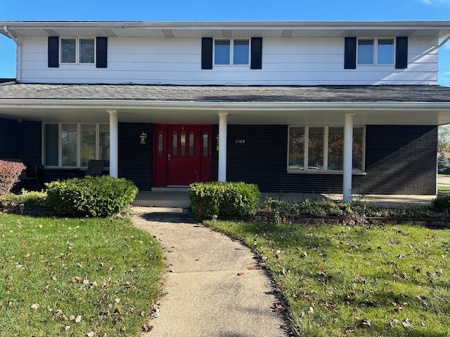 view of front of home with a porch and a front yard