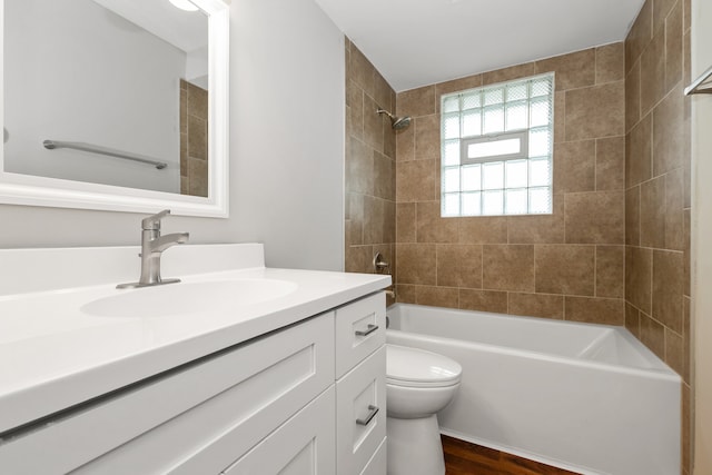 full bathroom featuring toilet, vanity, tiled shower / bath combo, and hardwood / wood-style flooring