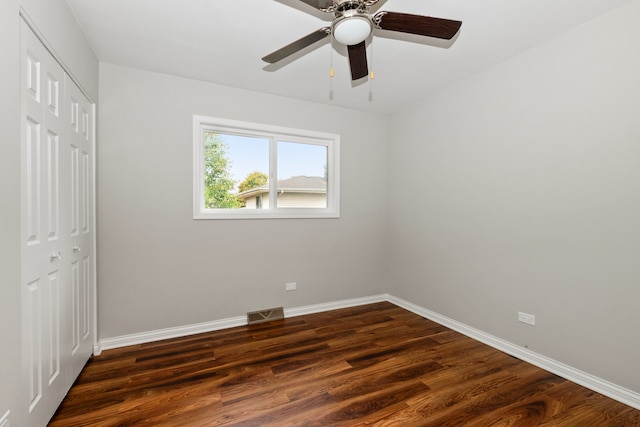 unfurnished bedroom featuring ceiling fan, a closet, and dark hardwood / wood-style floors