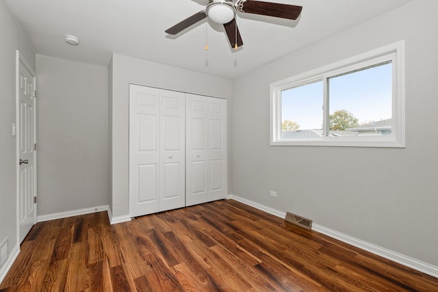 unfurnished bedroom with a closet, dark hardwood / wood-style floors, and ceiling fan