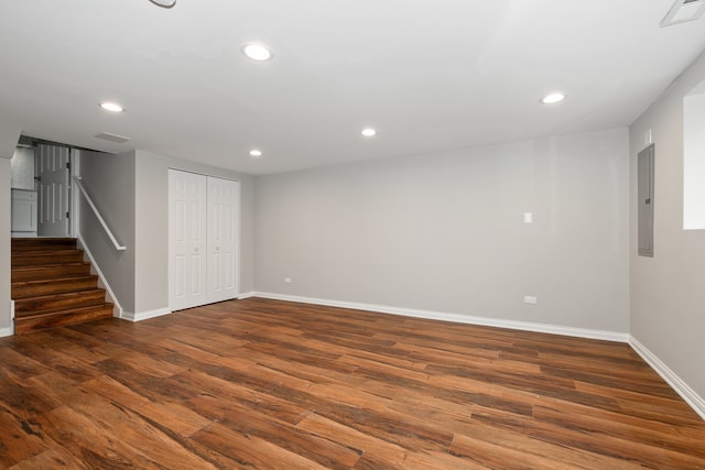 basement featuring electric panel and dark hardwood / wood-style flooring