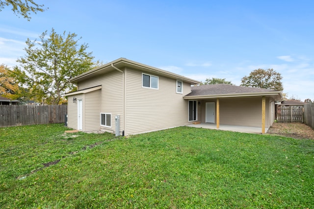 back of house featuring a lawn and a patio