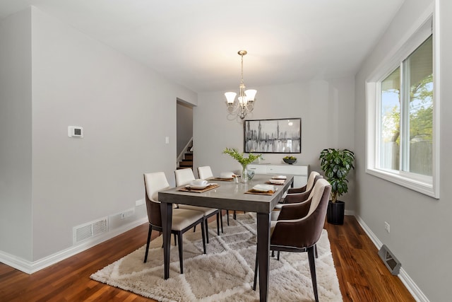 dining room featuring hardwood / wood-style flooring and an inviting chandelier